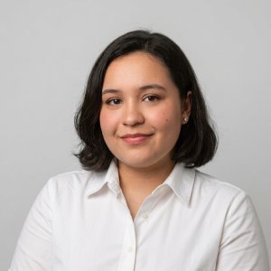 Uma mulher, com idade entre 20 e 25 anos, está olhando para a foto. Ela tem cabelo longo e ruivo
